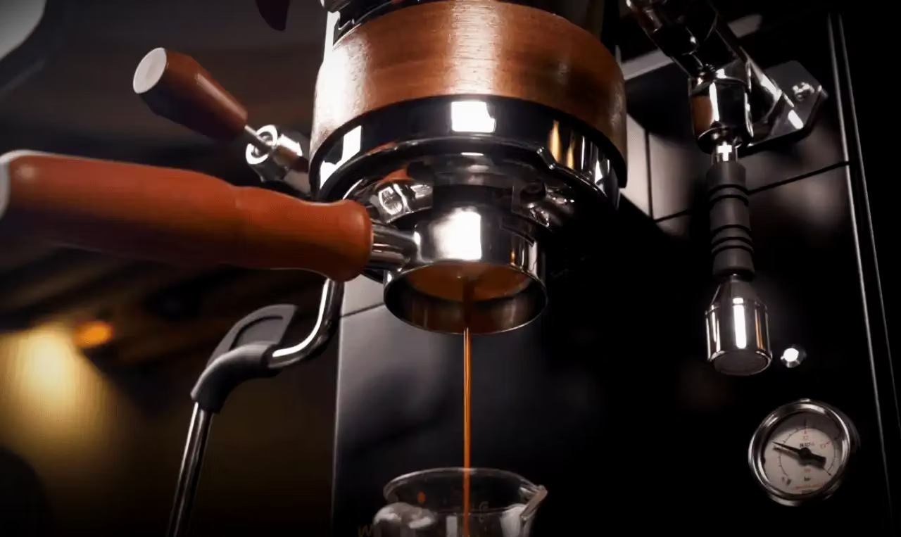 Detail of espresso machine pouring coffee, part of the Beginner Espresso Guide for perfect brewing.