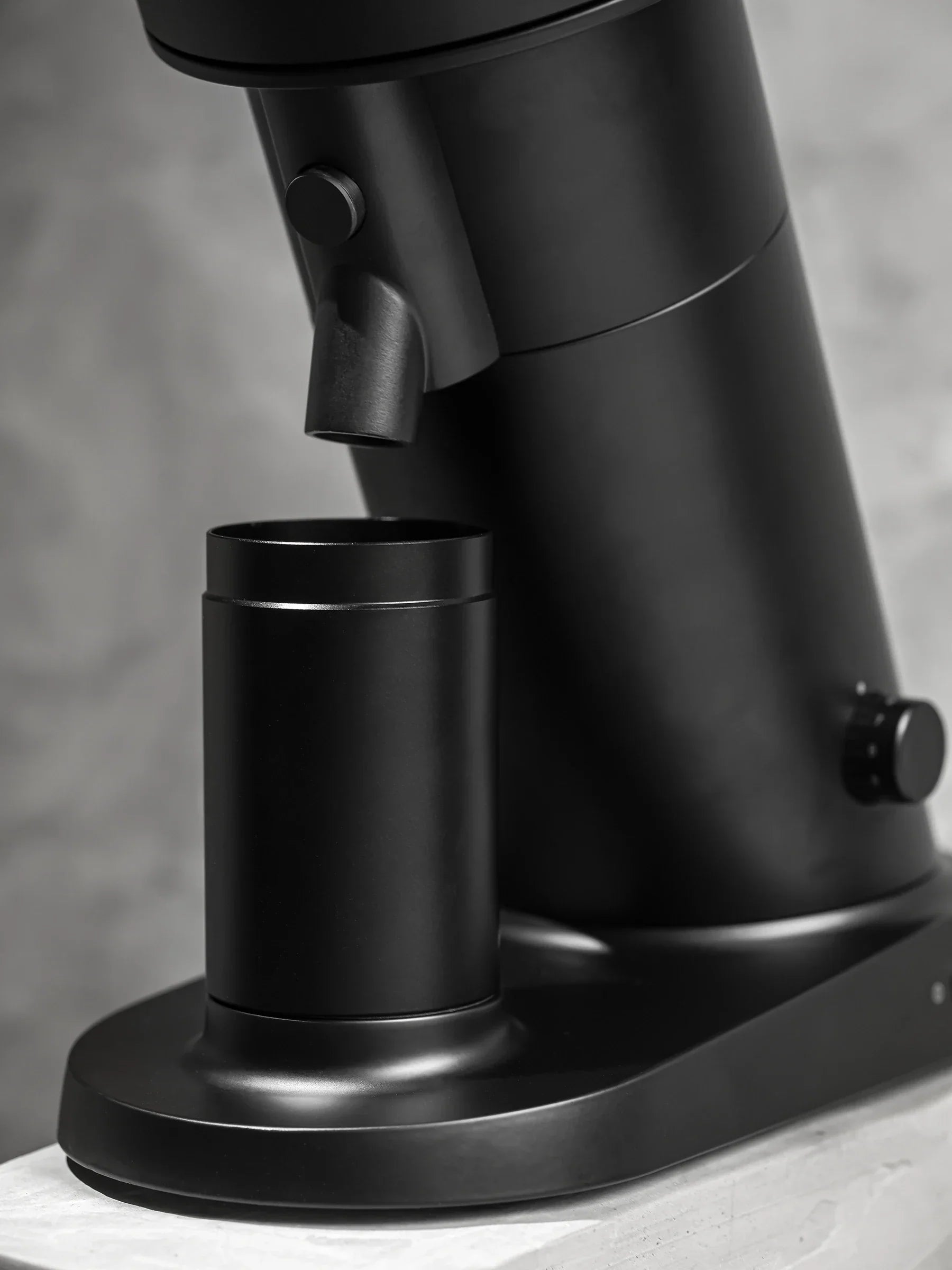 Close-up of the WPM ZP1 Single Dose Grinder showing the black base and magnetic dosing cup.